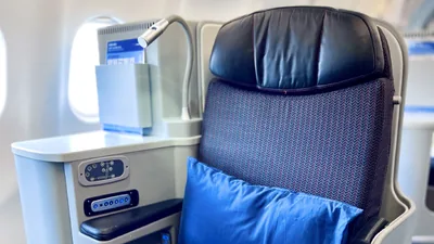 Kursi Business Malaysia Airlines posisi duduk, dengan panel kontrol kursi di sandaran tangan