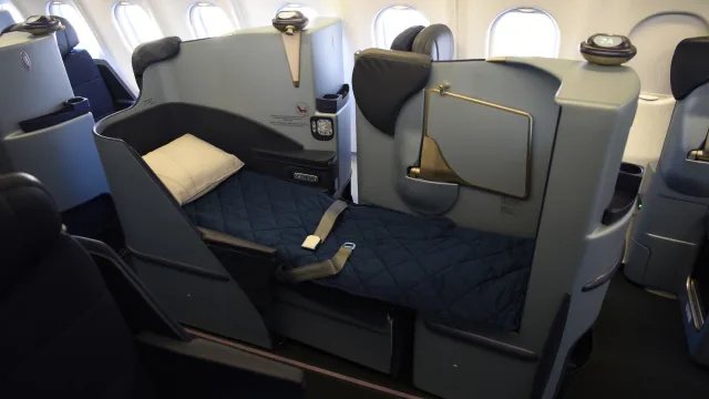 Kursi Business Malaysia Airlines dalam posisi berbaring rata, sudah dialasi kasur dan bantal