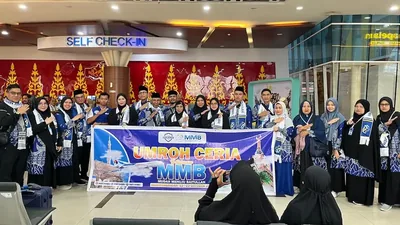 Rombongan jamaah umroh MMB Travel dengan spanduk Umroh Ceria di area check-in bandara