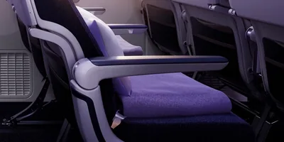 Detail kursi Economy Riyadh Air: sandaran tangan dan ruang di depan kursi